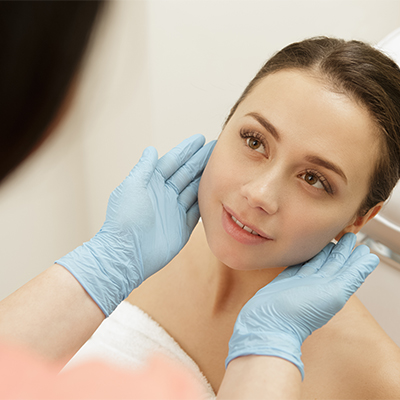 Girls face with doctor's gloves